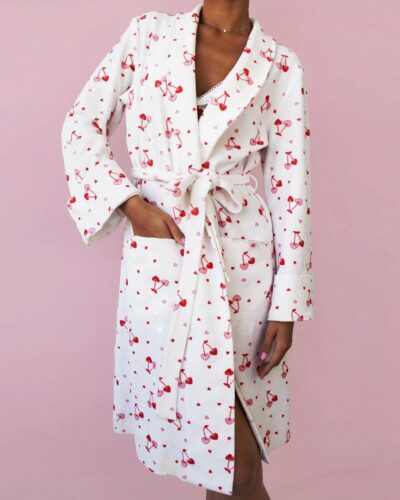 Peignoir Spa à Motif Cerise pour Femme, de couleur blanche, porté par une femme sur un fond rose.