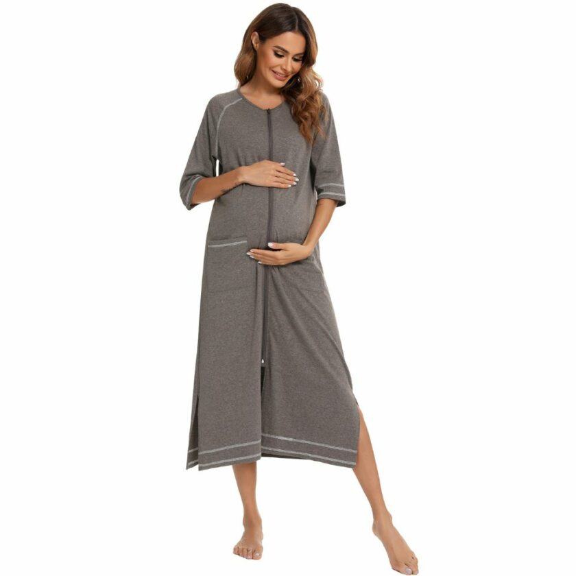 Une femme portant un peignoir long à manches 3/4 et fermeture éclair sur un fond blanc