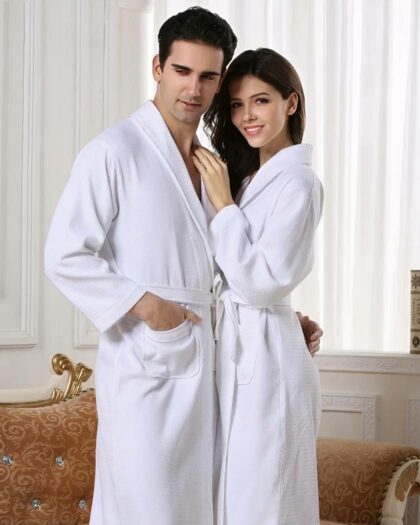 Un couple debout portant un peignoir hôtel blanc