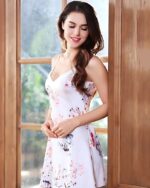 Nuisette courte blanche ornée de motifs floraux délicats, avec des fines bretelles et une coupe élégante pour un style raffiné.