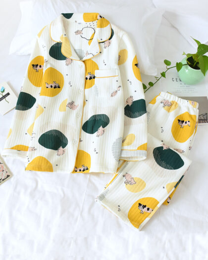 Pyjama femme été japonais avec imprimés d'animaux posé sur un support blanc. Composés d'un haut et d'un bas. ont des motifs jaunes et vert avec des imprimés de vache et cochon.
